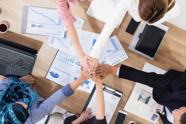 Takım çalışması çalışanları toplantıda el ele tutuşuyor.