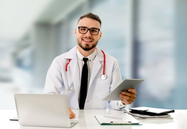 Hastanede tablet bilgisayar kullanan bir doktor..