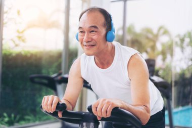 Fitness merkezinde bisiklet makinesi üzerinde Kıdemli adam egzersiz