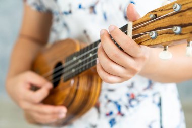 Stüdyoda ukulele çalan mutlu kadın müzisyen.