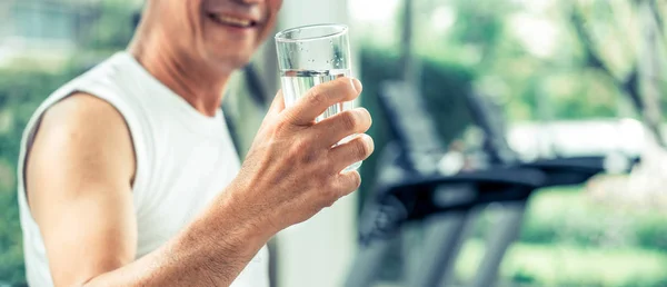 Senior man drink mineral water in fitness center. — Stock Photo, Image