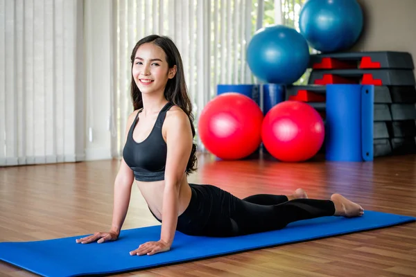 Mujer joven practica yoga en un estudio de gimnasia . —  Fotos de Stock