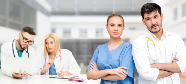 Dokter werkzaam in het ziekenhuis met andere artsen. — Stockfoto