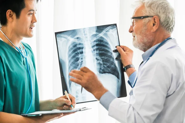 Médicos que trabajan con radiografías del tórax del paciente . — Foto de Stock