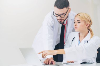 Hastanedeki doktor ortağıyla bilgisayar başında çalışıyor.