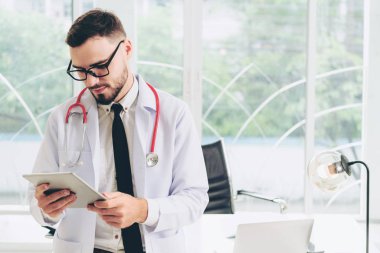 Hastanede tablet bilgisayar üzerinde çalışan doktor.