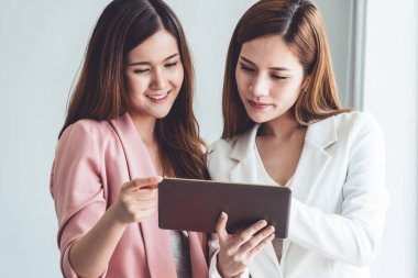 Ofiste tablet bilgisayar kullanan iş kadınları.