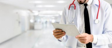 Hastanede tablet bilgisayar kullanan bir doktor..