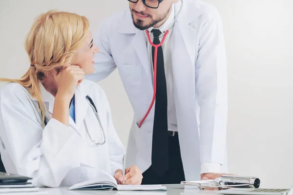 Docteur écrit rapport au bureau avec un autre médecin . — Photo