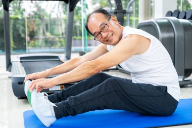 Kıdemli adam fitness merkezinde vücut germe yapmak.