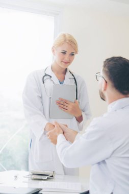 Hastanedeki doktor başka bir doktorla el sıkışıyor
