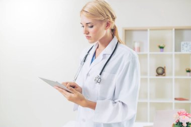 Hastane ofisinde çalışan genç kadın doktor.