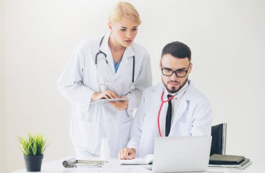 Hastanedeki doktor ortağıyla bilgisayar başında çalışıyor.