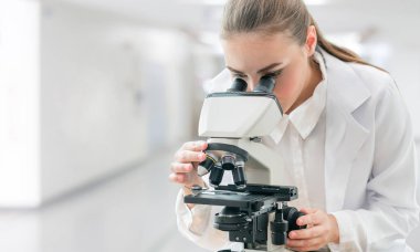 Bilim adamı araştırmacı laboratuvarda mikroskop kullanır