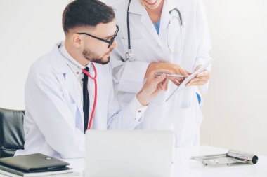 Hastanedeki doktor ortağıyla bilgisayar başında çalışıyor.