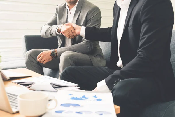 Businessmen handshake business deal in office.