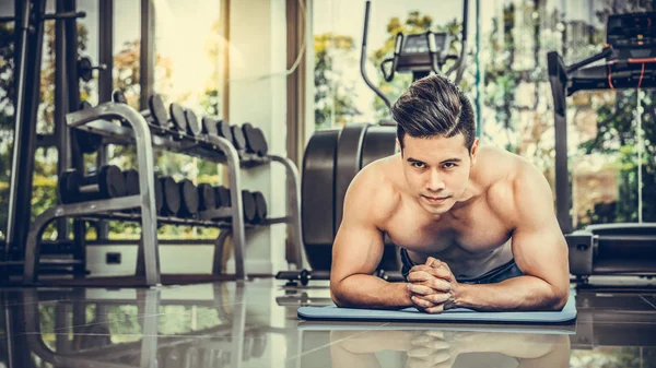 Hombre joven culturista empujar hacia arriba en el gimnasio . —  Fotos de Stock