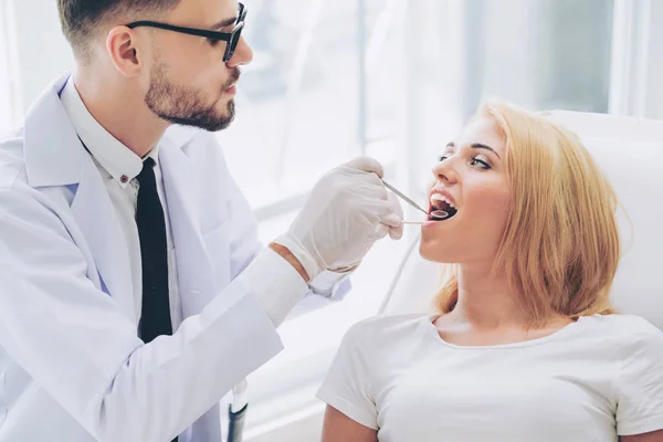 Young dentist examining patient in dental clinic. — Stock Photo, Image