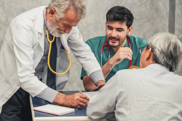 Equipo médico masculino hablando con la visita del paciente senior — Foto de Stock