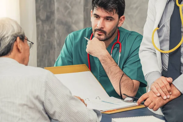 Equipe médica masculina conversando com a visita do paciente sênior — Fotografia de Stock