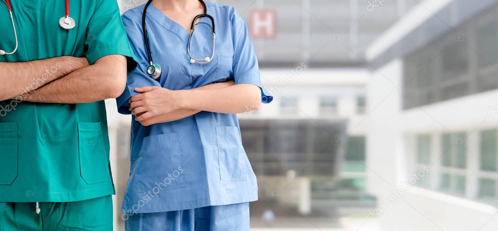 Doctor and surgeon with arms crossed in hospital.