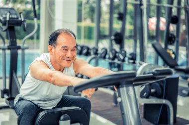 Fitness merkezinde bisiklet makinesi üzerinde Kıdemli adam egzersiz
