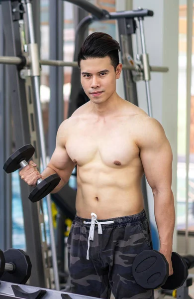 Μυώδης άνδρας bodybuilder κατάρτισης με αλτήρες. — Φωτογραφία Αρχείου