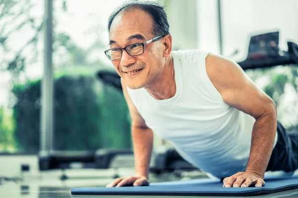 Senior man push up in fitness gym. — Stockfoto