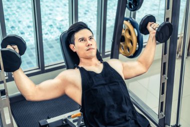 Kaslı adam vücut geliştirmeci dumbbells ile eğitim.