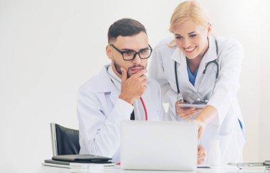 Hastanedeki doktor ortağıyla bilgisayar başında çalışıyor.