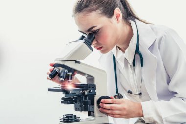 Hastane laboratuvarında mikroskop kullanan doktor.