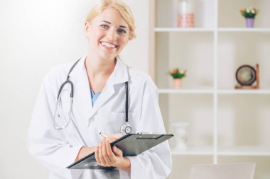 Hastane ofisinde çalışan genç kadın doktor.