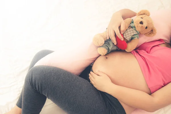 幸せな妊娠中の女性ベッドルームでベッドで寝て. — ストック写真