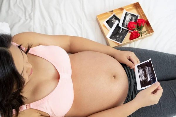 Mujer embarazada feliz y esperando un bebé en casa. — Foto de Stock