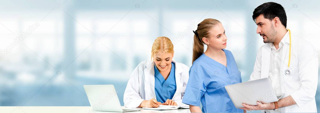 Doctor working in hospital with other doctors.