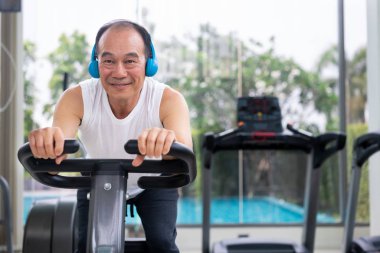 Fitness merkezinde bisiklet makinesi üzerinde Kıdemli adam egzersiz