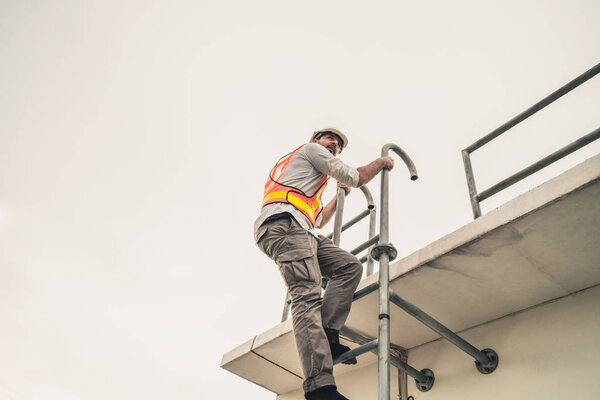 Young man worker or engineer climb ladder.