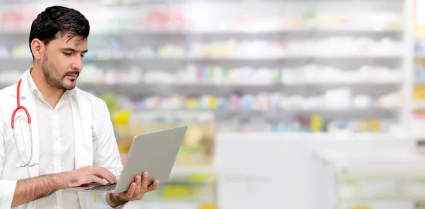 Farmacêutico usando computador portátil na farmácia . — Fotografia de Stock