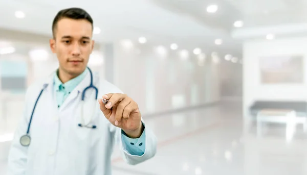 Médico apontando caneta no espaço vazio para o seu texto. — Fotografia de Stock