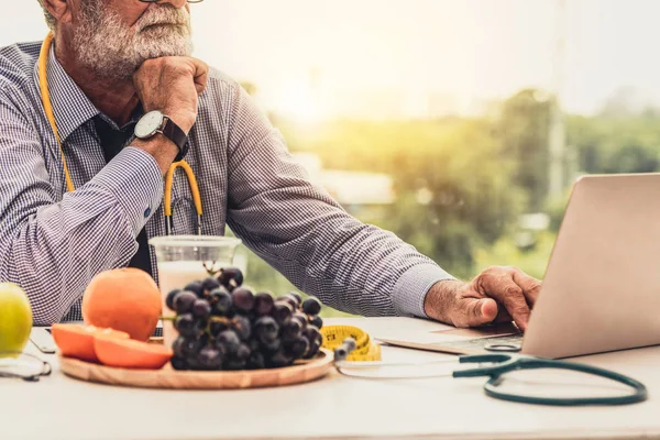 Senior médico nutricionista masculino que trabaja en el ordenador portátil . —  Fotos de Stock