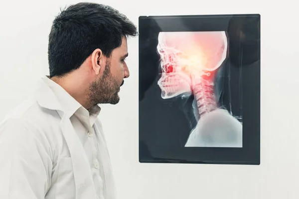 Ung manlig läkare som arbetar med patient Xray film. — Stockfoto