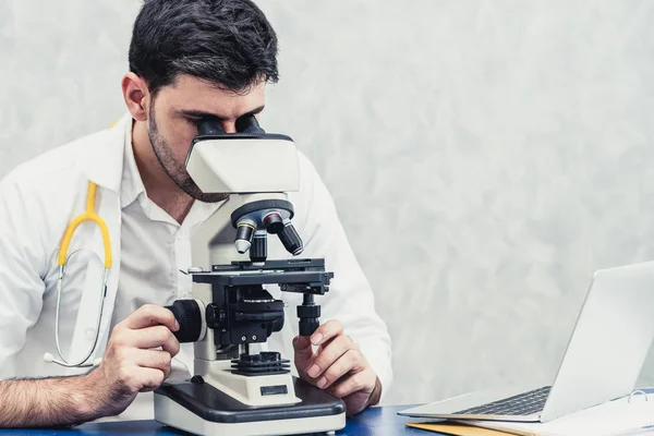 Médico usando microscópio em laboratório hospitalar . — Fotografia de Stock