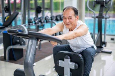 Fitness merkezinde bisiklet makinesi üzerinde Kıdemli adam egzersiz
