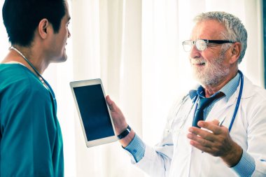 Hastanede tablet bilgisayarla çalışan doktorlar.