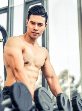 Kaslı adam vücut geliştirmeci dumbbells ile eğitim.