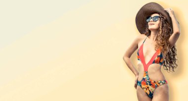 Renkli arka planda poz veren mayolu kadın.