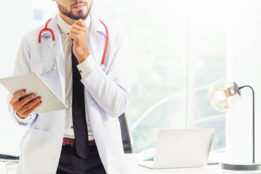 Hastanede tablet bilgisayar üzerinde çalışan doktor.