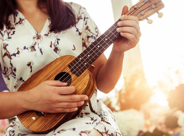 Boldog asszony zenész játszik ukulele stúdióban. — Stock Fotó