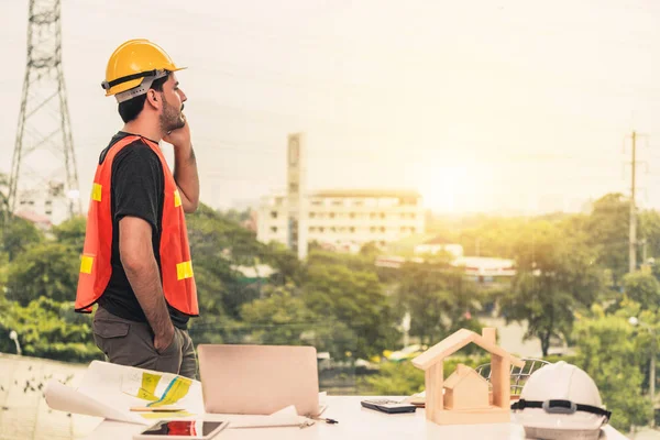 Ung man arkitekt eller ingenjör som arbetar vid skrivbordet. — Stockfoto