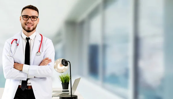Przystojny lekarz stojący w Szpital biuro. — Zdjęcie stockowe